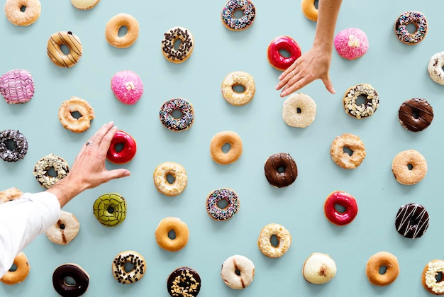 Photo hands selecting a variety of donut flavour