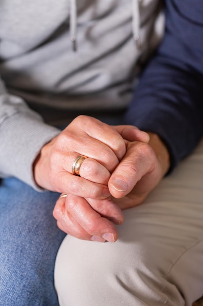 Hands of senior couple holding together care and support