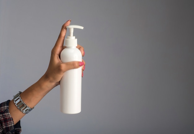 Hands showing a bottle of sanitizing gel for hands cleaning.