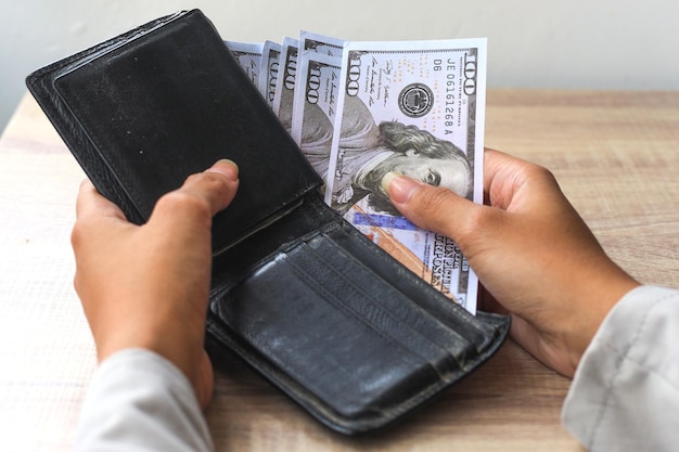 Hands take out money from wallet on the table