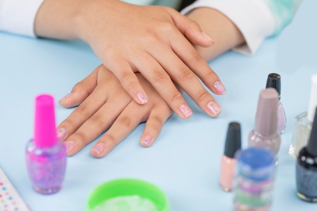 Hands of a teenage woman who has just painted her nails at home