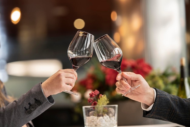 Hands toasting with glass of wine to celebrate new year