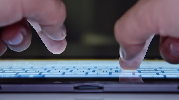 Hands typing on keyboard of tablet computer