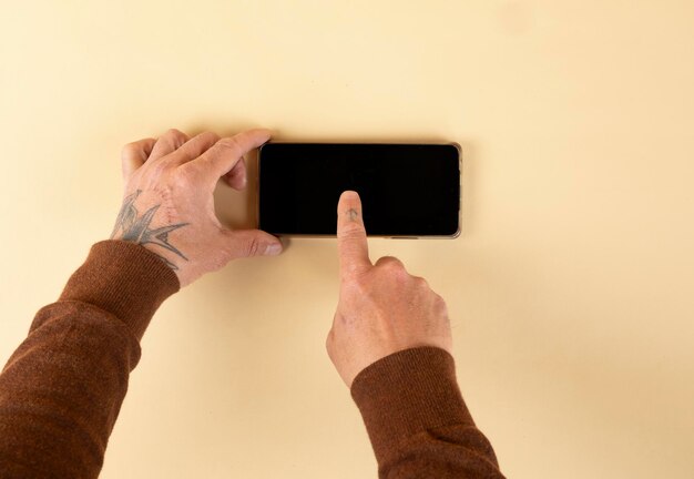 hands using mobile phone isolated on a pastel colored background