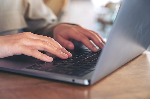 hands using and typing on laptop keyboard on the table