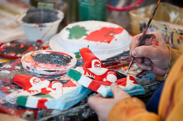 Hands while painting a paper puppet in Viareggio Italy Carnival Show