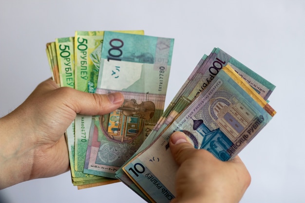 Hands with Belarusian money on a white background Belarusian currency on a white background