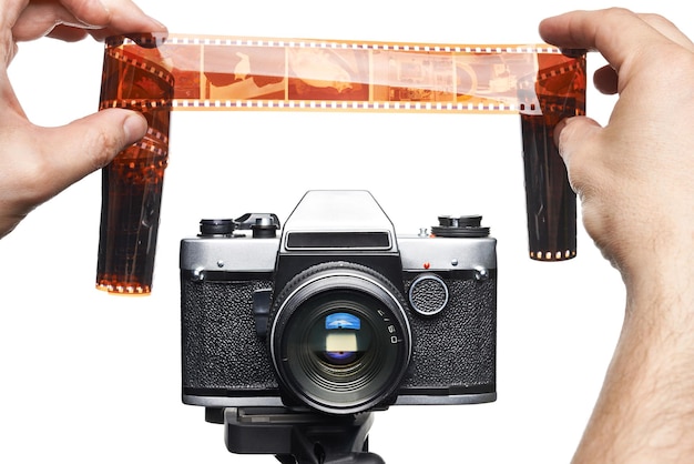 Hands with color negative near SLR camera isolated