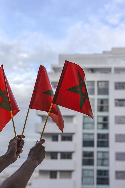 Hands with flags of Morocco with defocused background