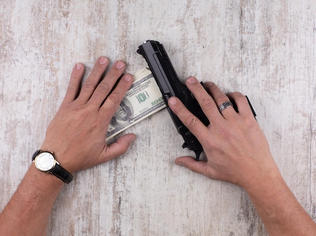 hands with gun and dollars