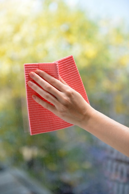 Hands with napkin cleaning window