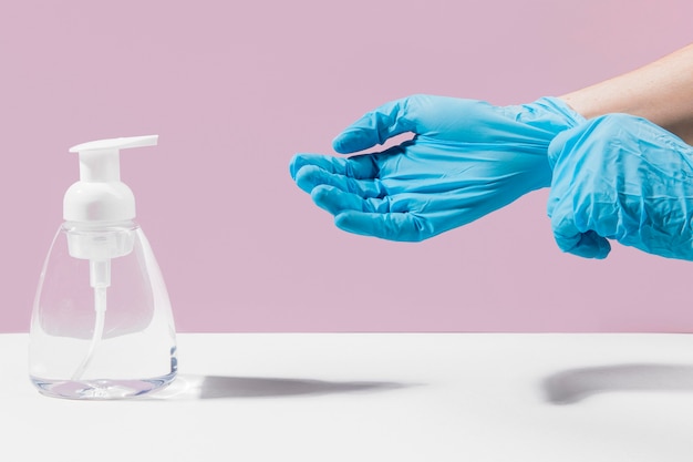 Hands with surgical gloves using hand sanitizer