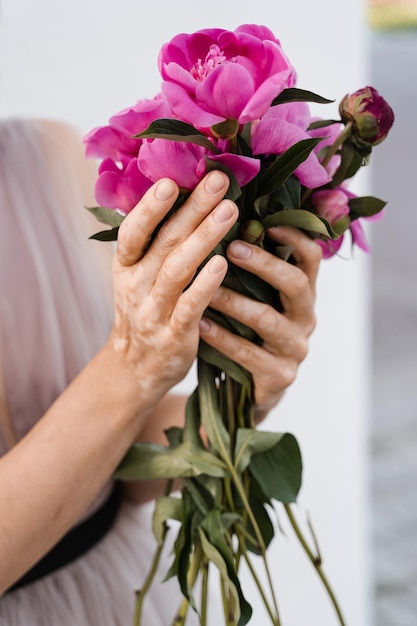 Hands with vitiligo skin pigmentation and bouquet of flowers peonies Skin seasonal diseases