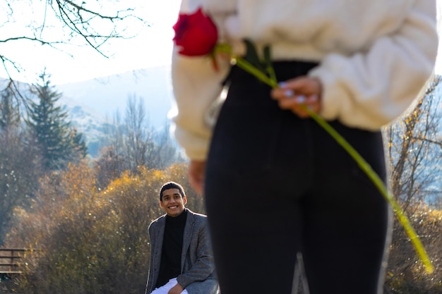 Hands of a woman in love hiding a rose for her boyfriend Concept of a rose for the boyfriend