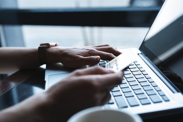 Hands of Woman shopping in Internet, making instant Payment Transaction at Computer, using Credit Card.