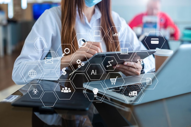 Hands of woman using mobile phone in modern office with laptop and digital tablet computer with VR icon diagram at office in morning lightxA