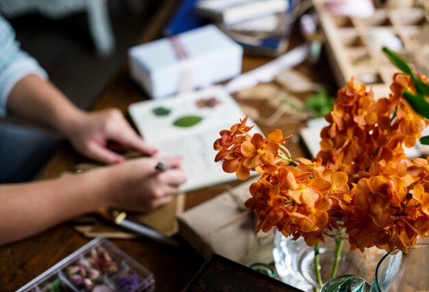 Hands writing diary on the table with orchid decorate