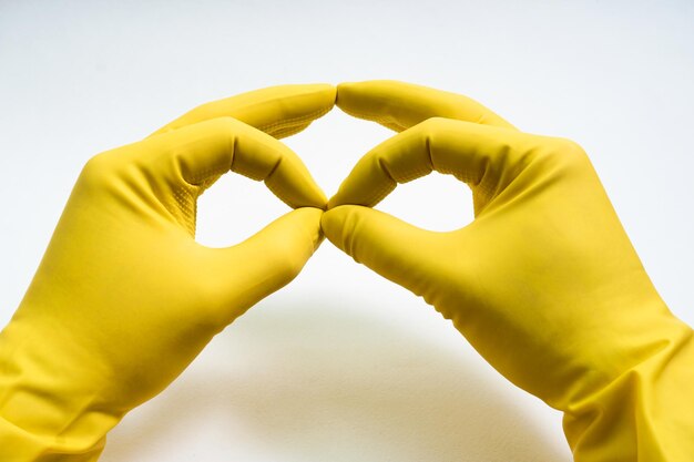 Photo hands in yellow rubber gloves on white background