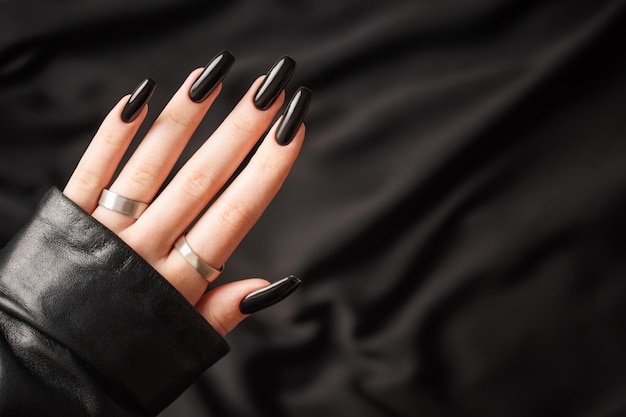 Hands of a young girl with black manicure on nails