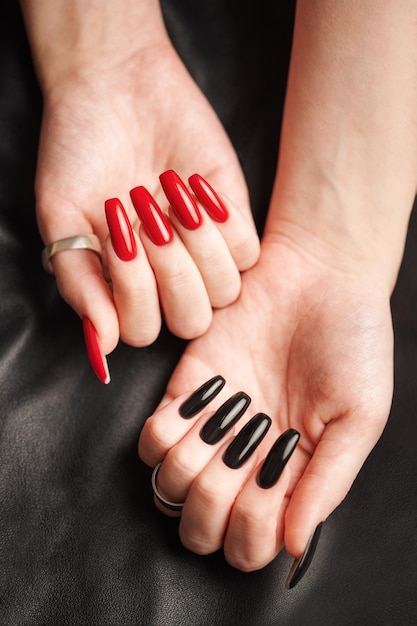 Hands of a young girl with black and red manicure on nails