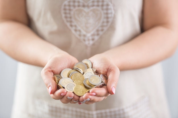 Hands of young hosewife holding euro coins.