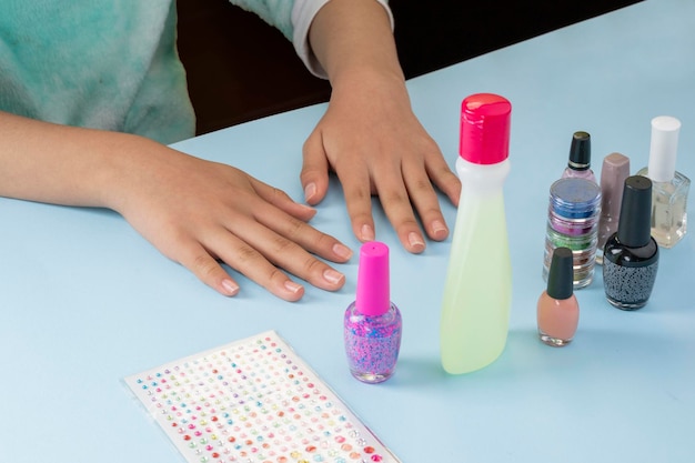 Hands of a young Latin woman who is going to paint her nails with varnishes and accessories