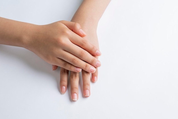 Hands of a young woman hand and nail care with white background and copy space