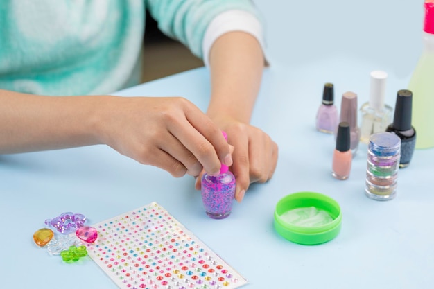 Hands of a young woman with a nail varnish in her hands to paint her nails at home