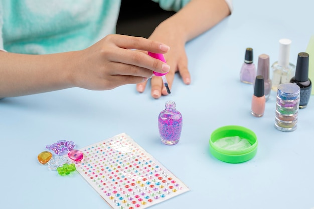 Hands of a young woman with a nail varnish in her hands to paint her nails at home