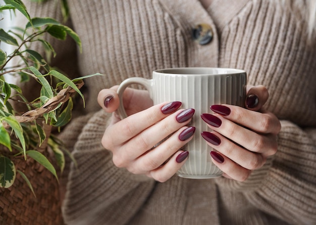 Hands of a young woman with white manicure on nails