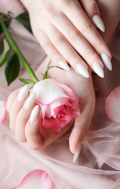 Hands of a young woman with white manicure on nails