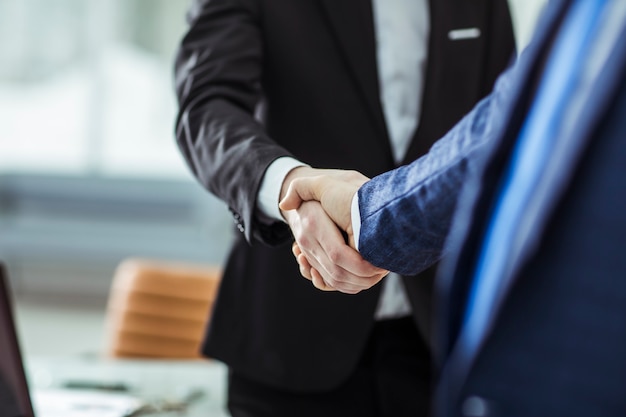 handshake of business partners on the background of bright office.