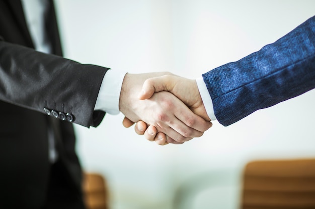 handshake of business partners on the background of bright office.