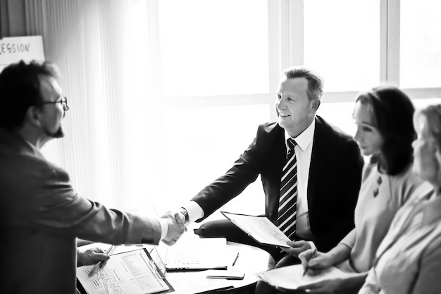 Handshake of senior business partners on the Desk in the office