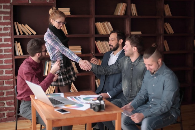 Handshake of two designers at a working meeting in the office