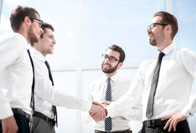 Photo handshake of young business partners standing in the office