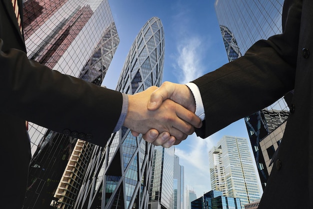 Handshaking of businessmen on city background Teamwork meeting and partnership concept