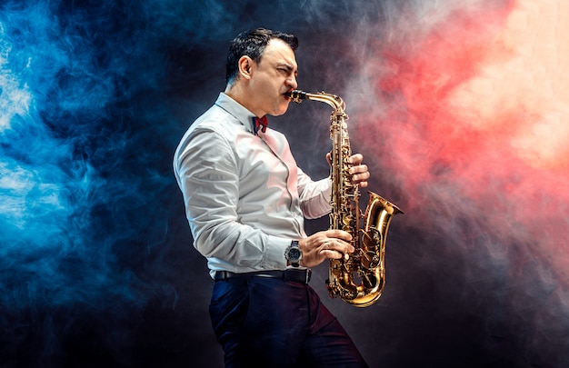 Handsome adult man playing saxophone