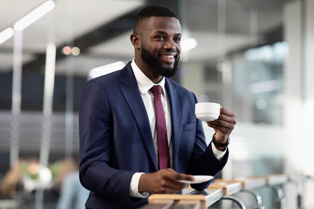 Handsome african american businessman having coffee break at office