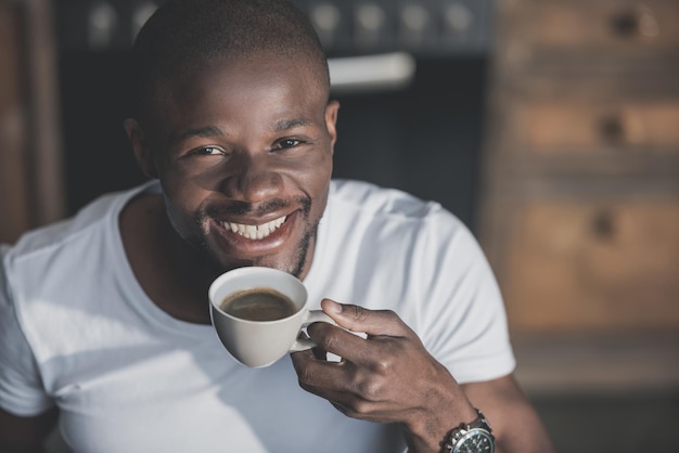 Handsome african american man having his morning coffee at home