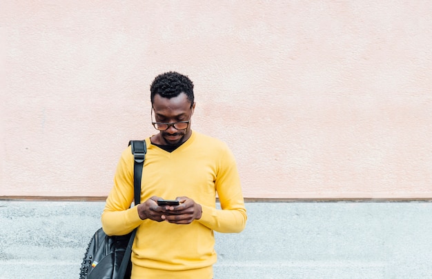 Handsome African American man using smartphone.