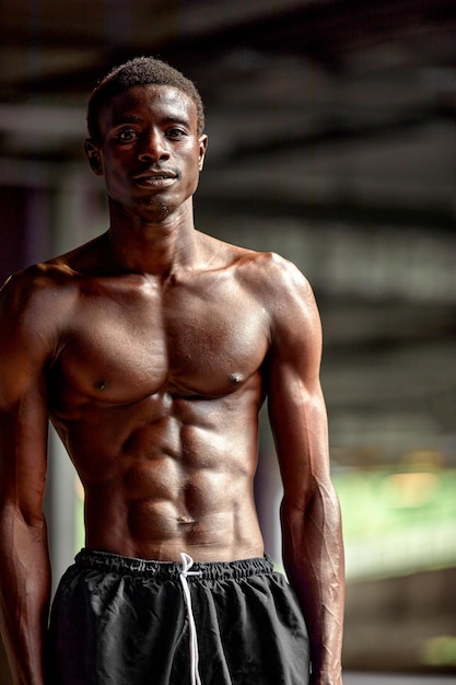 Handsome African American sportman standing on the street while taking break after training Black male having rest after workout