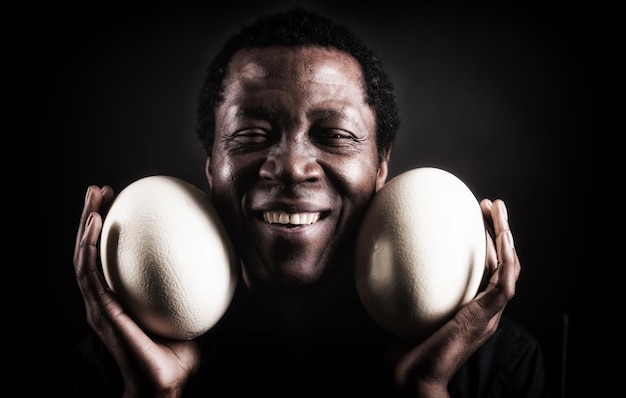 Handsome african black man with ostrich egg