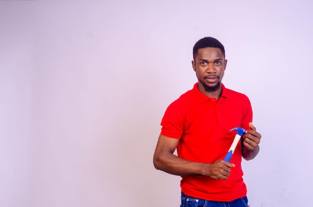 Handsome african man isolated over white background holding hammer