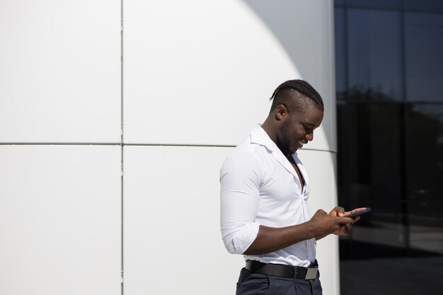 handsome african man in white shirt with mobile phone