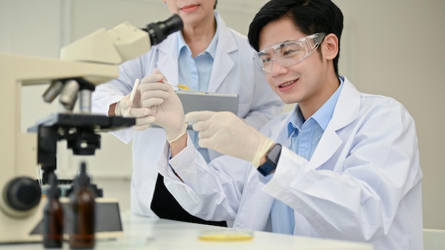 Handsome Asian male scientist working in the laboratory with his colleague