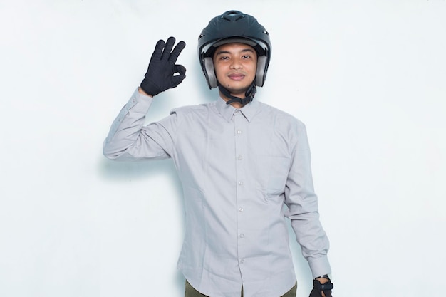 Handsome asian man with a motorcycle helmet showing a thumbs up ok gesture on white background