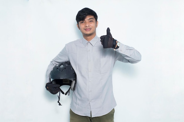 Handsome asian man with a motorcycle helmet showing a thumbs up ok gesture on white background