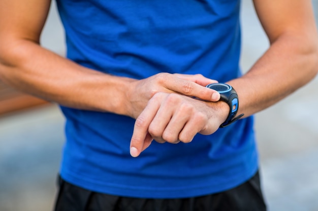 An handsome athlete looking at his watch