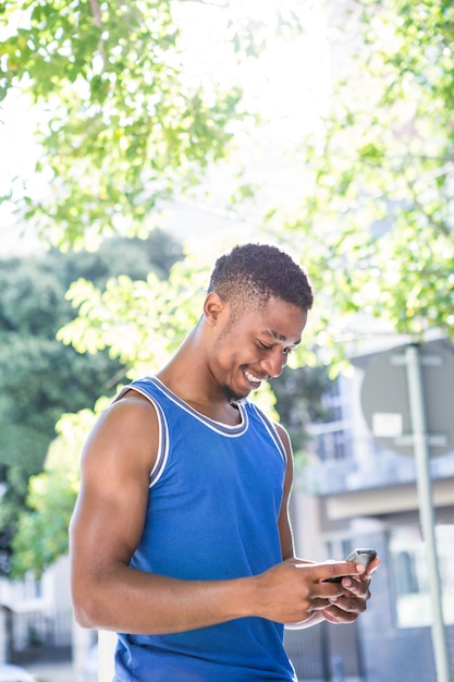 An handsome athlete using his phone